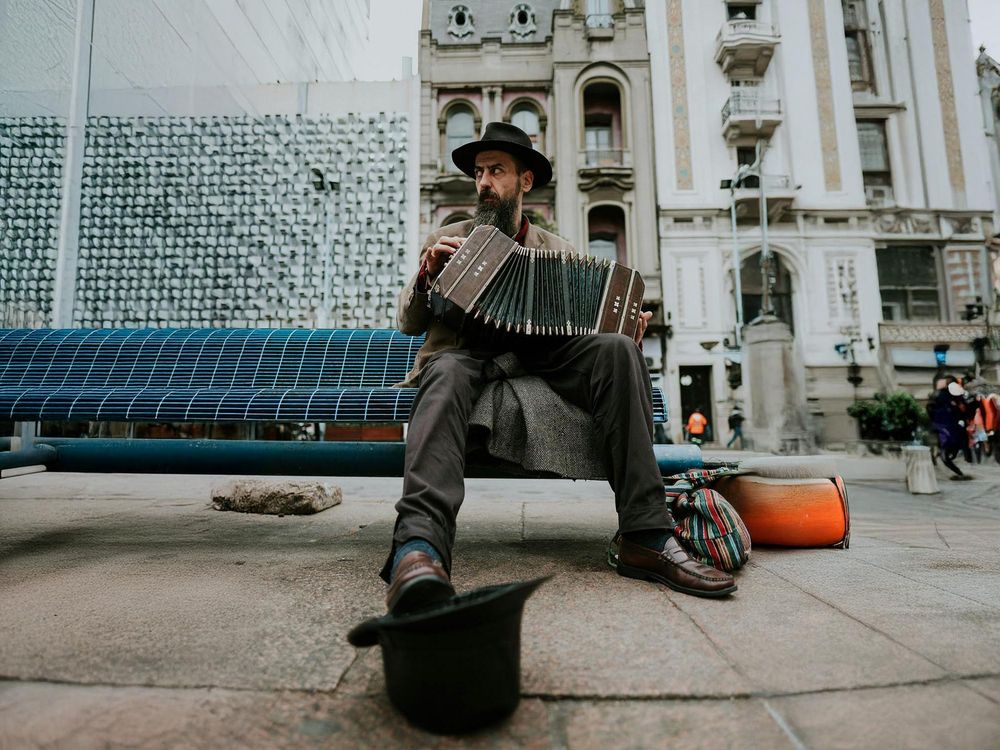 picture of a man on a bench playing the accordeon